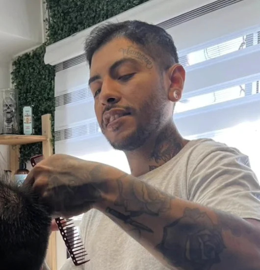 Hernán Castillo trabajando en un servicio de barbería